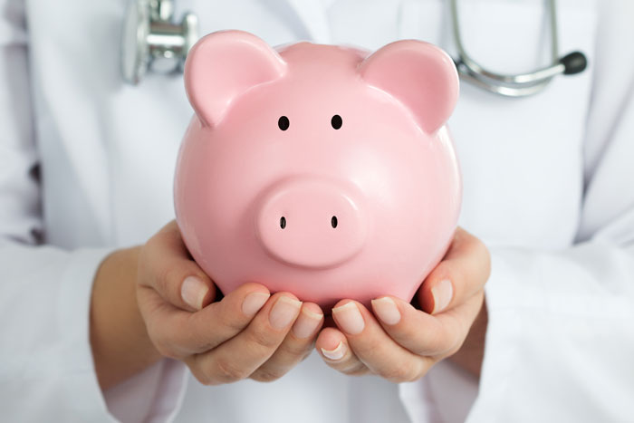 female doctor hands holding a pink piggy bank to symbolize health savings accounts or HSA