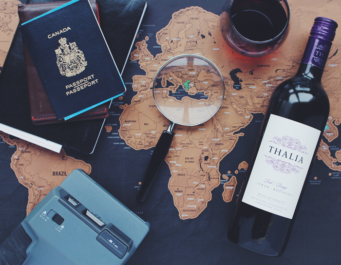 map with magnifying glass, wine, camera, and passport